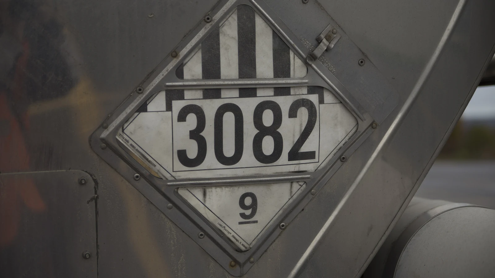 Знак опасности класса 9 с номером ООН 3082 на металлической цистерне